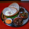 The hopper set includes rice flour pancakes, two curries and sambols.
