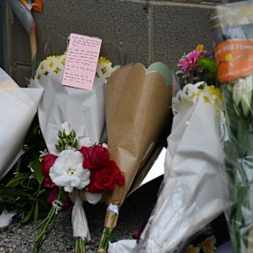 A small shrine of flowers grows by the school fence.