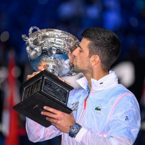 Novak Djokovic gets his hands on the Australian Open trophy in 2023.
