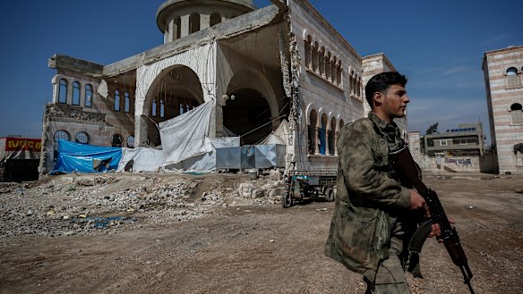 A Turkey-backed opposition fighter of the Free Syrian Army secures the streets of the north-western city of Azaz, Syria.