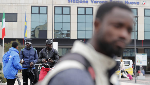 Migrants stand in front of Verona's railway station. Racist and anti-Semitic expressions have been growing more bold, widespread and violent in Italy.