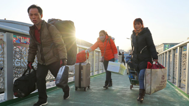 Migrant workers on an overpass near Beijing Railway Station, part of the world's biggest annual human migration.