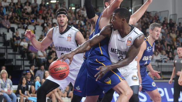 Melbourne United Casey Prather makes a pass to teammate Josh Boone around the defence of Brisbane's Tom Jervis.