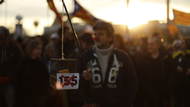 A pro independence demonstrator holds a box with the sign 155 in reference of the article 155 of the Spanish Constitution leading to direct rule over Catalonia by the Spanish government during a protest the detention of deposed leader of Catalonia's pro-independence party Carles Puigdemont in Barcelona.