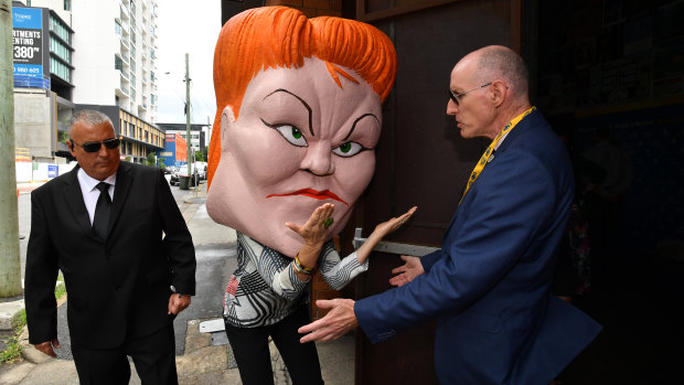 A protester wearing a mask depicting Pauline Hanson is seen outside the LNP campaign launch of Tim Nicholls held at The Triffid.