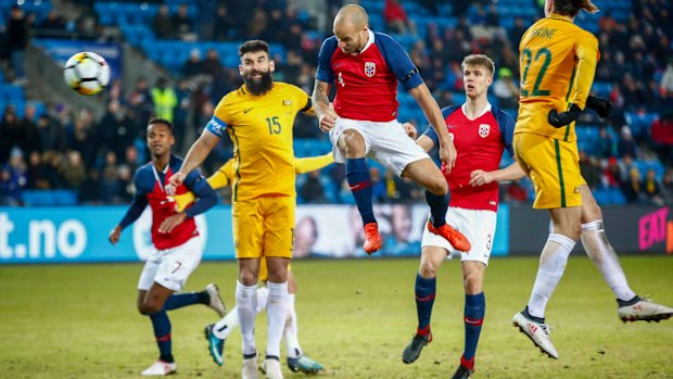 Rising up: Tore Reginiussen leaps for a header to take the lead for Norway at 2-1.