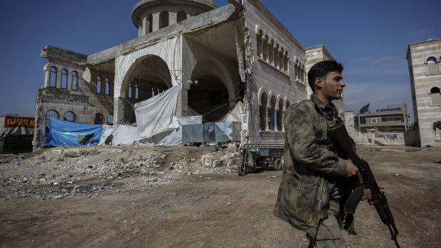 A Turkey-backed opposition fighter of the Free Syrian Army secures the streets of the north-western city of Azaz, Syria.