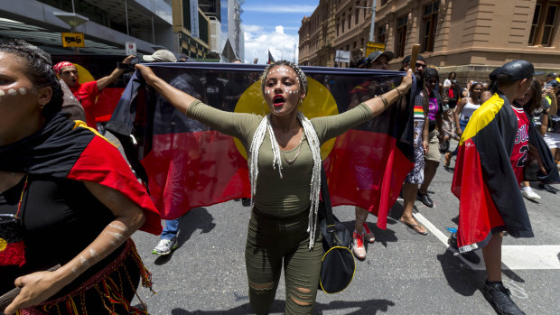 Protestors participate in an Invasion Day march in Brisbane on Friday.
