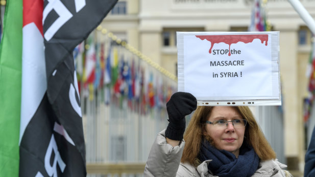 Demonstrators hold banners in solidarity with the Syrian people during a rally against the bombing of Syria on the Place des Nations, in front of the European headquarters of the United Nations in Geneva.