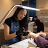 A nail artist at work at Buff Nails in Fitzroy. 
