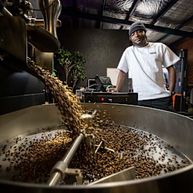 David Juma roasts coffee beans in the large factory space.