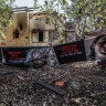 Banners showing members of the Shoham family that were abducted by Hamas on October 7th outside their damaged home in Kibbutz Beeri.