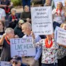 An anti-Woolworths development demonstrator confronts a YIMBY heckler at a community rally in Elsternwick.