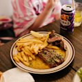 Steak with “umami butter” is cooked over a wood grill.
