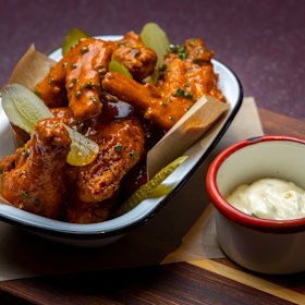 Louisiana chicken wings come with pickles and ranch dressing.