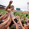GWS Giants AFLW players lift Grace Kos in the air at a training session at ENGIE Stadium.