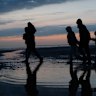 Migrants run across the beach at first light last month to board small boats that had come to collect them in Gravelines, France, for the journey across the English Channel.
