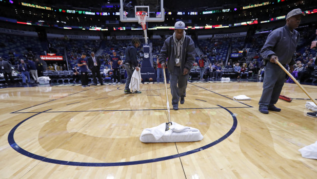 Workers mop the court.