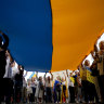 People hold a Ukrainian flag in Buenos Aires, Argentina on Saturday to mark the second anniversary of Russia’s invasion of Ukraine.