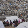 Palestinians displaced by the Israeli air and ground offensive it in a makeshift tent camp inside a landfill in central Gaza Strip on Friday.