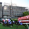 Horses race past the rising apartment development at Moonee Valley Racecourse.