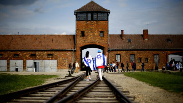 Young visitors with Israeli flags walk on railway tracks on the grounds of the former German Nazi death camp Auschwitz-Birkenau near Oswieciem, Poland, in 2015.