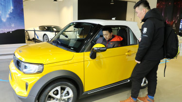 Li Hongbo (inside car) and Li Peng (outside car) look around BJEV’s latest model - Arcfox Lite at a showroom in Sanlitun, Beijing.