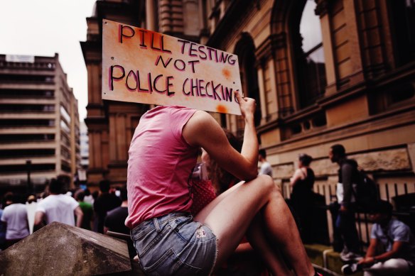 An attendee holds up a sign at a pill testing rally held at Sydney's Town Hall on Saturday.
