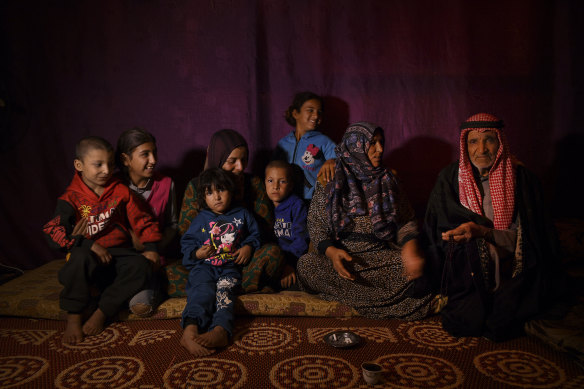 Abir (second from right) talks to her husband Mahmoud, 70, inside their temporary shelter in the Bekaa Valley.