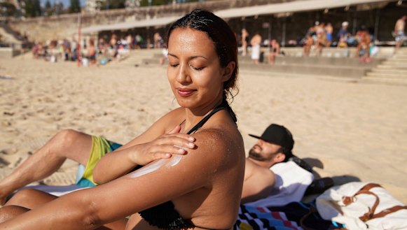 Serene Amaral from Waterloo applies some sunscreen at Coogee Beach on Sunday, when temperatures hit 38 degrees.