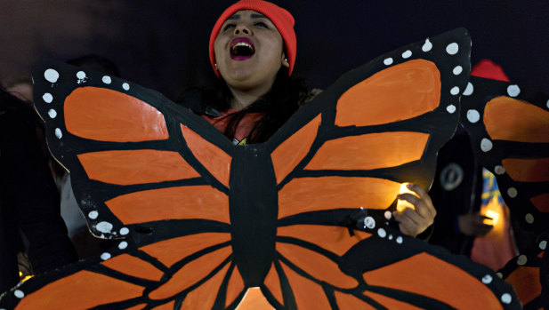A demonstrator chants while wearing a butterfly cutout during a rally supporting the Deferred Action for Childhood Arrivals program (DACA), or the Dream Act, outside the US Capitol building in Washington, on Sunday.
