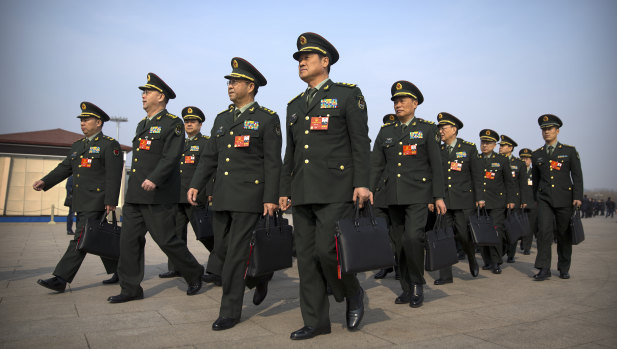 Military delegates arrive for a plenary session of China's National People's Congress (NPC) at the Great Hall of the People in Beijing, on Friday.