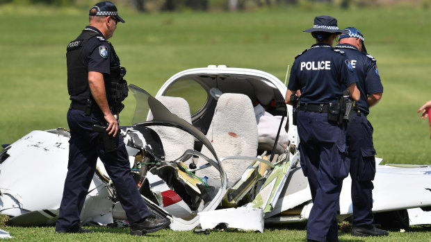 Police look over the wreckage at the scene of a light aircraft crash at Allenview, Tuesday, September 26, 2017. Two men are dead after a light plane crashed on a turf farm south of Brisbane.