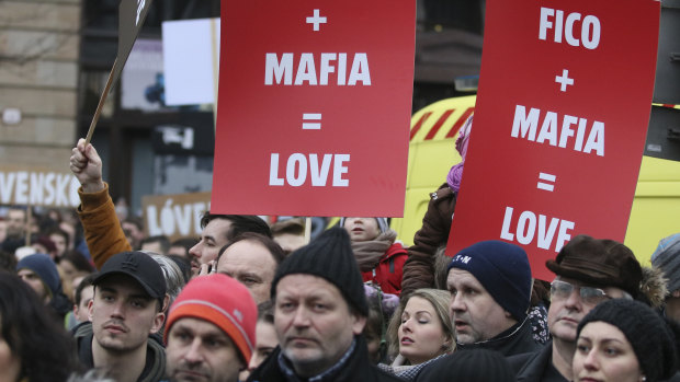 Demonstrators hold posters linking Slovakian Prime Minister Robert Fico to the mafia during an anti-government rally in Bratislava, Slovakia, on Friday.