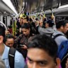 Commuters pack a city-bound metro train during the morning peak.