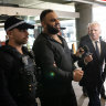 Masood Zakaria is escorted by Police at Sydney airport after his arrest and extradition from Turkey.