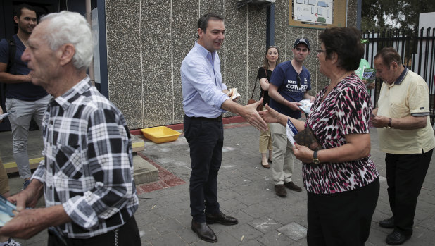 Every last vote: Steven Marshall hands out how-to-vote cards at a primary school on election day. 