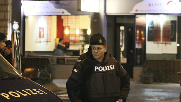 A police officers stands in front of a Japanese restaurant after several people were injured in a knife attack in Vienna on Wednesday.