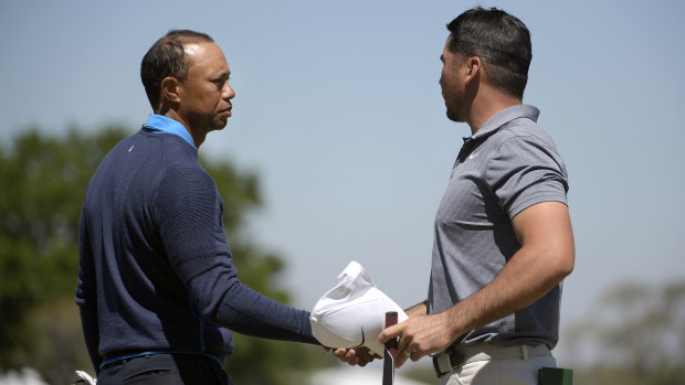 Tiger Woods shakes hands with Australian playing partner Jason Day.