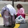 A homeless person sits outside a cyclone refuge centre in Brisbane, on March 7, as the city prepares for the arrival of cyclone Alfred.