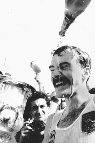 Champagne celebration ... De Castella savours one of his favourite victories,