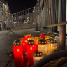 A pedestrian walk past candles at the site of a stabbing attack in Villach, Austria.