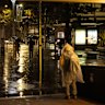 Pedestrians brave the rain in Manly early on Monday morning.