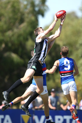 Collingwood's Mason Cox takes a strong mark, before kicking one of his four goals. 