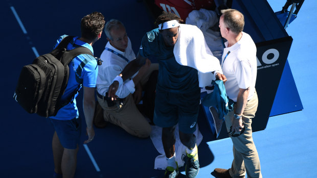 Gael Monfils of France is seen by doctors during his Australian Open match against Novak Djokovic.