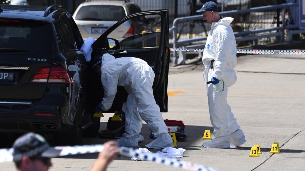 Police inspecting Hawi's bullet-ridden car. 