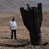 A man looks at the wreckage of an Iranian missile that landed near the West Bank city of Jericho on Monday.