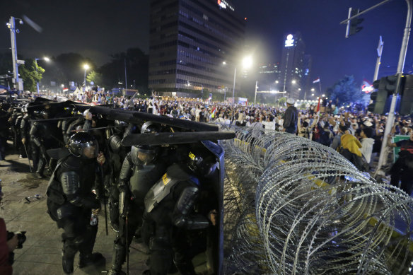 Riot police take defensive positions in central Jakarta.