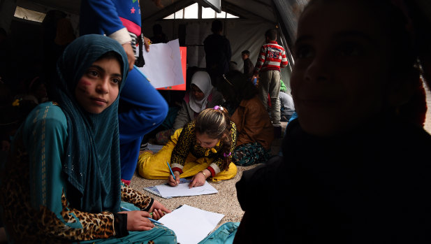 Twelve-year-old Luma (center in a yellow dress) saw her mother beaten and then shot dead in front of her by ISIS. She then carried her 18-month-old sister for 2 hours to safety.