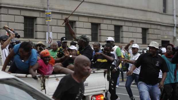 Members of the Black First Land First are attacked by African National Congress members protesting outside the ANC headquarters in Johannesburg on Monday.